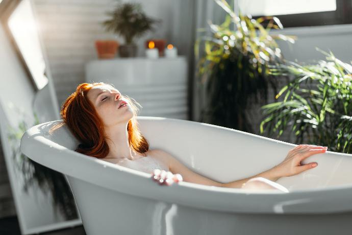Jeune femme rousse occupée à se détendre dans son bain